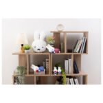 Miffy 睡眠公仔粉紅色裙子藍花朵款與其他Miffy公仔放在書架上