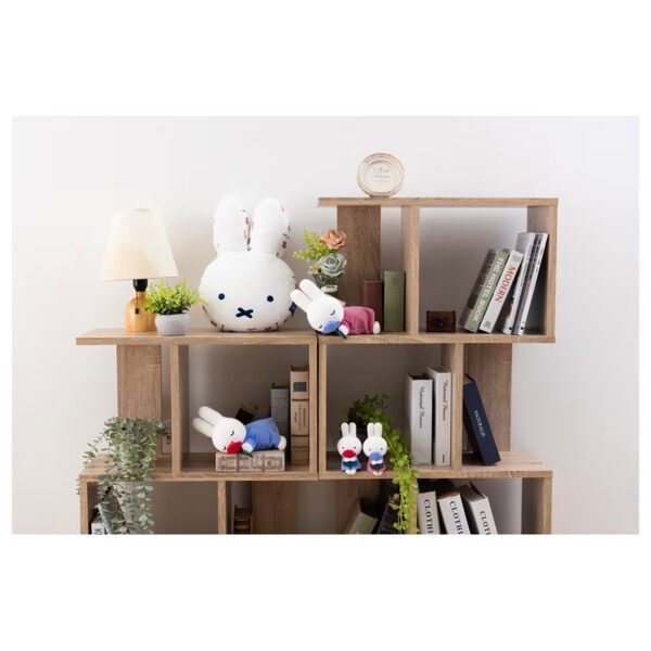 Miffy 睡眠公仔粉紅色裙子藍花朵款與其他Miffy公仔放在書架上