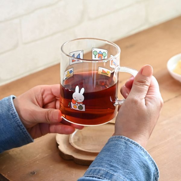 Miffy 耐熱玻璃杯 – 畫畫款,杯子裡裝了茶雙手捧在手裡的樣子