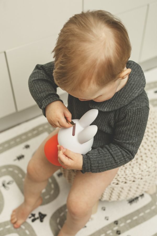 Miffy 造型存錢罐 - 小孩把硬幣放進紅色Miffy 存錢罐