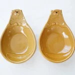 Yoshizawa 益子燒海狸造型碗焦糖色的正面視圖，垂直展示，左側顏色較深，右側顏色較淺 - Front view of Yoshizawa Mashiko-style caramel-colored beaver-shaped bowls, displayed vertically, with one darker and one lighter in color.