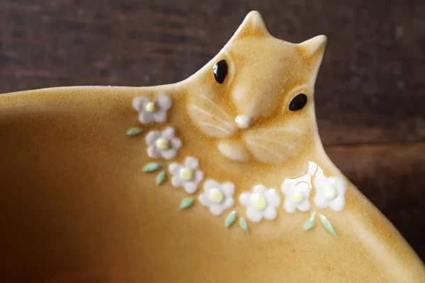 Yoshizawa 益子燒松鼠碗的頭部特寫，清楚展示頭部細節和粉紅色花朵項鍊 - Close-up of the head of a Yoshizawa Mashiko-style squirrel bowl, clearly showing the head details and the pink flower necklace.