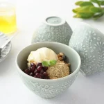 三個淡綠色杯子，其中一個裝着食物，另外兩個展示不同角度的圖片