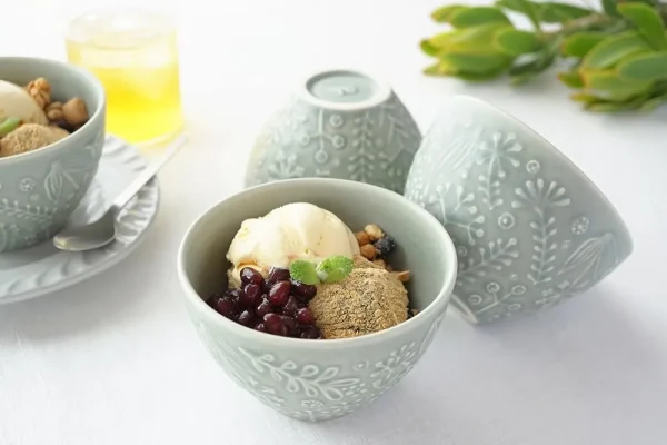 三個淡綠色杯子，其中一個裝着食物，另外兩個展示不同角度的圖片