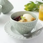 淡綠色杯子裝着食物放在碟上