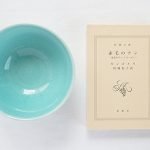 Yoshizawa 益子燒森林動物飯碗兩個與小冊子放在一起的俯視圖