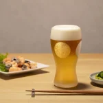 日本製 ADERIA 石塚硝子 金箔日月紋磨砂啤酒杯禮盒杯子放在木枱上，枱上還有其他碟子裝着食物