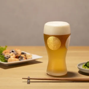 日本製 ADERIA 石塚硝子 金箔日月紋磨砂啤酒杯禮盒杯子放在木枱上，枱上還有其他碟子裝着食物