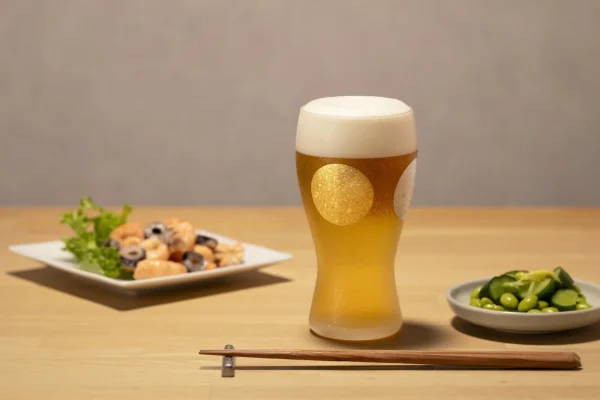 日本製 ADERIA 石塚硝子 金箔日月紋磨砂啤酒杯禮盒杯子放在木枱上，枱上還有其他碟子裝着食物