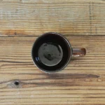 啡色的 Studio M' Mountain 直角手柄粗陶杯放在木枱上的俯視圖。