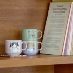 三種不同顏色的I LOVE CAT！貓咪陶瓷杯疊放在書架上