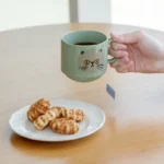 手上拿着綠色CDF ètendue I LOVE CAT！貓咪面圖案可堆疊陶瓷杯