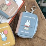 Miffy 書本造型智能鑰匙包 黃色・粉紅色・藍色, 木桌上三色產品展示照